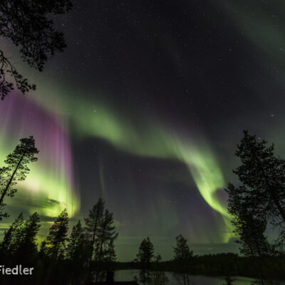 Ein intensives, farbenfrohes Polarlicht zeigt sich übern dem See Pohjaslampi.